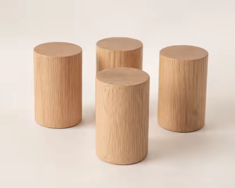 Four cylindrical light-oak bed legs on a pale surface